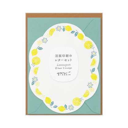 Die-cut curved sheet with a two-color border of lemons and blossoms with a teal envelope.